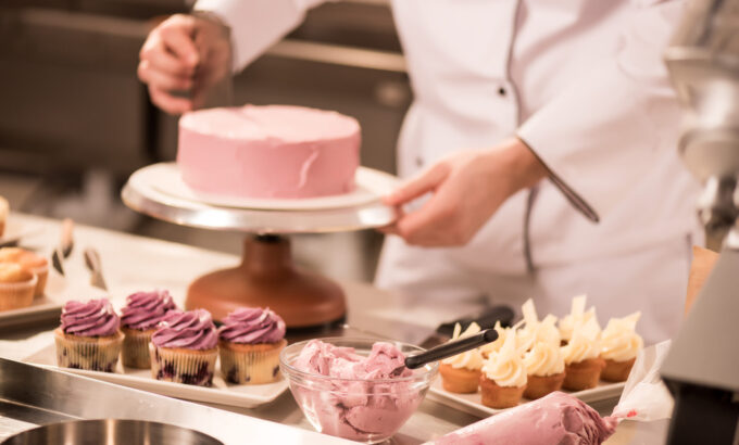 cropped shot of confectioner making cake in restaurant kitchen cropped shot of confectioner making cake in restaurant kitchen